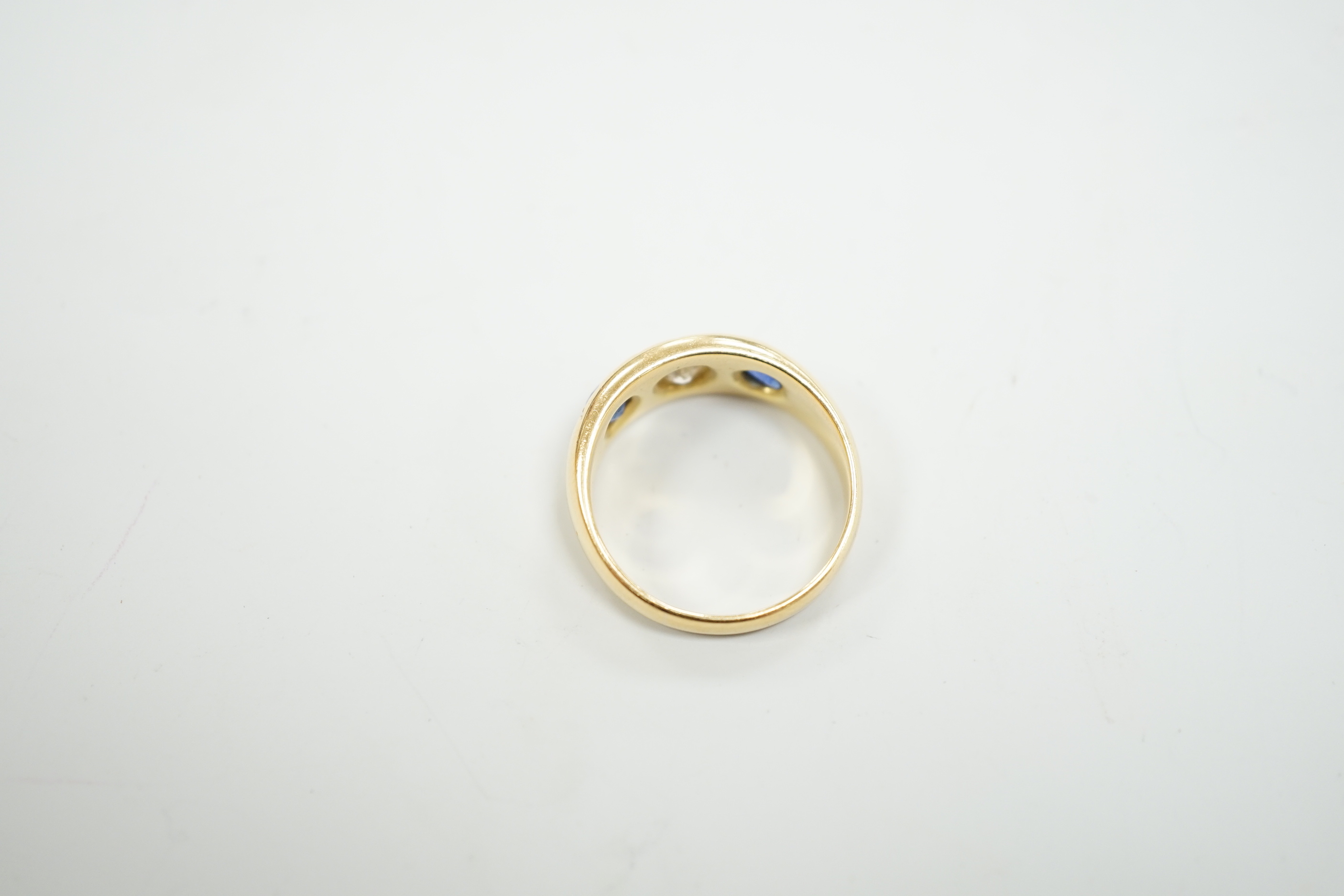 An early 20th century 18ct gold and gypsy set single stone diamond and two stone sapphire set ring, size O, gross weight 6.4 grams.